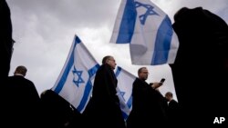 FILE - Israeli lawyers wave the national flag during a protest against the government's plans to overhaul the country's legal system outside the District Court in Tel Aviv, Israel, Jan. 12, 2023.