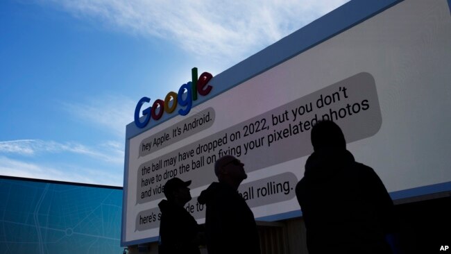 FILE - Workers set up a Google billboard at the Las Vegas Convention Center ahead of the CES technology show on January 2, 2023, in Las Vegas.