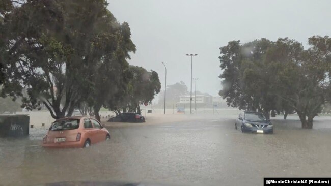 This screen grab from a social media video shows water flooding a street during heavy rainfall in Auckland, New Zealand, Jan. 27, 2023. (Courtesy of @MonteChristoNZ via Reuters)