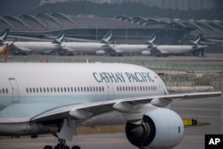 FILE - Pesawat Cathay Pacific di Bandara Internasional Hong Kong, 25 November 2022. Hong Kong akan memberikan tiket pesawat dan voucher untuk merayu wisatawan kembali mengunjungi pusat keuangan internasional tersebut. (AP/Vernon Yuen, File)