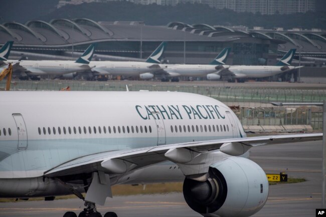 FILE - Penerbangan Cathay Pacific di Bandara Internasional Hong Kong, 25 November 2022. Hong Kong akan menyediakan tiket pesawat dan voucher untuk menarik wisatawan kembali ke pusat keuangan internasional itu.  (AP/Vernon Yuen, Berkas)