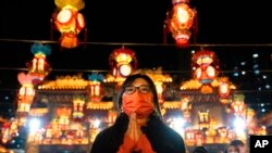 A woman offers prayer at the Wong Tai Sin Temple, Jan. 21, 2023, in Hong Kong, to celebrate the Lunar New Year which marks the Year of the Rabbit in the Chinese zodiac. 