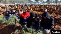 FILE: People react next to graves of victims of the deadly earthquake, in a cemetery in Kahramanmaras, Turkey. Taken Feb. 9, 2023