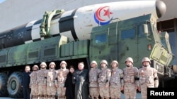 N. Korean leader Kim Jong Un and his daughter attend a photo session with the scientists, engineers and others involved in the test-fire of the new Hwasong-17 ICBM in this photo released Nov. 27, 2022 by N. Korea's KCNA via Reuters. 