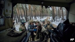 Médicos militares ayudan a un soldado herido a subir a un vehículo de evacuación cerca de Kremenna en la región de Luhansk, Ucrania, el 16 de enero de 2023.