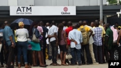 FILE - People queue to withdraw new naira notes from an Automated Teller Machine (ATM) on bank premises in Lagos, Feb. 1, 2023.