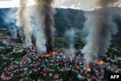 FILE - This aerial photo taken on Oct. 29, 2021 show smokes and fires from Thantlang, in Chin State, where more than 160 buildings were destroyed by shelling from Junta military troops, according to local media.