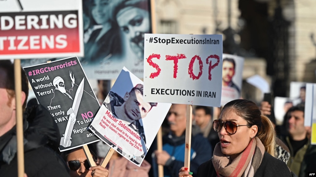 FILE - Protesters hold placards at a march in central London on Jan. 21, 2023, against the Islamic revolutionary Guard Corps. Thousands of Iranians based in Europe rallied in Paris on Saturday to urge the European Union to list Iran's Revolutionary Guards as a terror group.