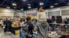 Para pengunjung, termasuk di antaranya anak kecil, melihat-melihat senjata api yang dijual di pameran senjata Crossroads of the West Gun Show di Ontario, California, pada 28 Januari 2023. (Foto: AFP/Apu Gomes)