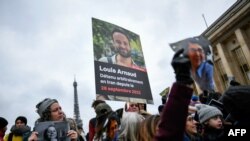 Demonstrators hold portraits of two of the French being detained in Iran — Cecile Kohler, left, and Louis Arnaud, center — during a rally in Paris to release the prisoners on Jan. 28, 2023. 