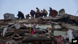 Rescatistas turcos trabajan para sacar a Ergin Guzeloglan, de 36 años, de un edificio derrumbado cinco días después de un terremoto en Hatay, en el sur de Turquía, la madrugada del sábado 11 de febrero de 2023.