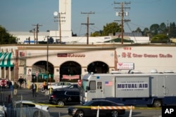 Penyelidik terlihat di luar Star Dance Studio di Monterey Park, California, Minggu, 22 Januari 2023. Penembakan massal terjadi di klub dansa setelah perayaan Tahun Baru Imlek, memicu perburuan terhadap tersangka. (AP/Jae C. Hong)