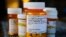 FILE - Several bottles of prescription medications including quetiapine, the chemical name for the drug Seroquel, sit arranged on a kitchen table at a home in Cross Lanes, W. Va., May 26, 2010.