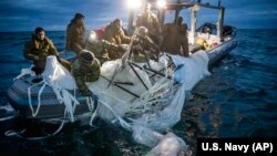 This image provided by the U.S. Navy shows sailors assigned to Explosive Ordnance Disposal Group 2 recovering a high-altitude surveillance balloon off the coast of Myrtle Beach, South Carolina, Feb. 5, 2023.