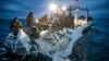 This image provided by the U.S. Navy shows sailors assigned to Explosive Ordnance Disposal Group 2 recovering a high-altitude surveillance balloon off the coast of Myrtle Beach, S.C., Feb. 5, 2023.