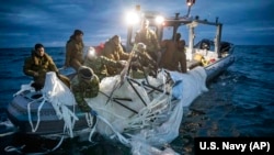 This image provided by the U.S. Navy shows sailors assigned to Explosive Ordnance Disposal Group 2 recovering a high-altitude surveillance balloon off the coast of Myrtle Beach, S.C., Feb. 5, 2023.