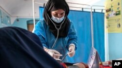 FILE - A midwife from NGO Save the Children provides a pregnant woman with a pre-natal check-up in Jawzjan province in northern Afghanistan, Oct. 2, 2022. (Save the Children via AP)