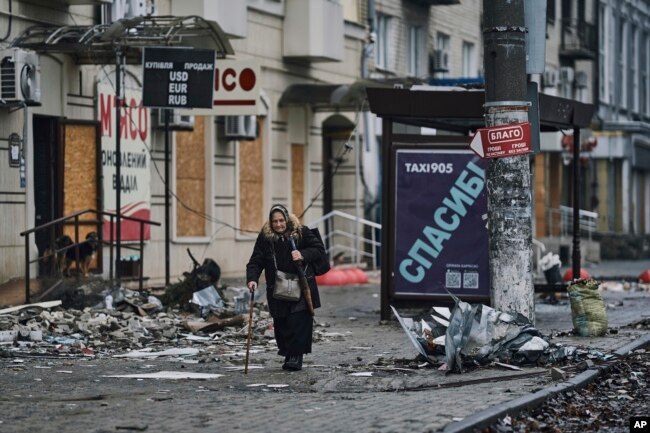 A local resident walks along a street in Bakhmut, in the Donetsk region, Ukraine, Saturday, Dec. 17, 2022. (AP Photo/LIBKOS, File)