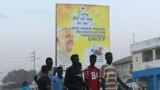 FILE: A group of young people walk past a banner showing the portrait of Pope Francis as preparations continue ahead of his visit in Juba, on January 31, 2023. 