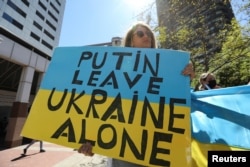 FILE - Members of Ukrainian Association of South Africa hold placards during a protest against the invasion by Russia in Ukraine, outside the Russian Consulate in Cape Town, Feb. 25, 2022.