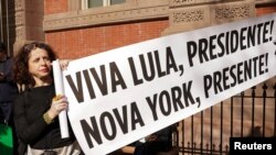 A supporter of Brazil's President Luiz Inacio Lula da Silva holds a sign outside Blair House, across from the White House, where Lula is staying in Washington, Feb. 10, 2023.