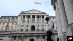A man walks down steps in front of the Bank of England in London, Thursday, Feb. 2, 2023. (AP Photo/Frank Augstein)