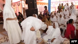 FILE - Newly-inducted Jain nuns take blessings of a senior nun as part of a ritual at a ceremony where they renounced their material lifestyles on the outskirts of Ahmedabad on April 25, 2018.