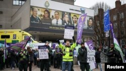FILE - People protest in front of the London Ambulance Service during a strike by ambulance workers due to a dispute with the government over pay, in London, Jan. 23, 2023. 