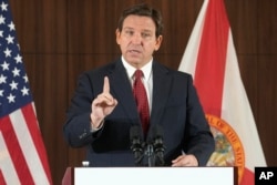 FILE - Florida Gov. Ron DeSantis gestures during a news conference, Thursday, Jan. 26, 2023, in Miami. DeSantis on Tuesday, Jan. 31, 2023, announced plans to block state colleges from having programs on diversity, equity and inclusion, and critical race theory. (AP Photo/Marta Lavandier, File)