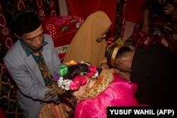 Dua remaja meminta restu orang tua setelah menikah di desa Tampapadang di Mamuju, Sulawesi Barat. (Foto: AFP)