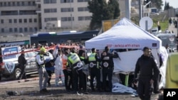 FILE- Zaka Rescue and Recovery team work at the site of a car-ramming attack at a bus stop in Ramot, in east Jerusalem, Feb. 10, 2023.