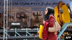 FILE - A visitor walks past a displayed machine during the 24th International Oil, Gas, Refining & Petrochemical Exhibition at Tehran Permanent Fairground in Tehran, May 1, 2019.