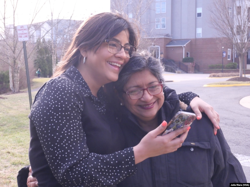 Ariadna Gutiérrez, a la izquierda, abraza a su madre, Evelyn Pinto, mientras hablan por teléfono con un familiar. Pinto, defensora de DD.HH., estuvo en la cárcel desde noviembre de 2021. 