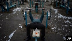 A man exercises at the Kachalka outdoor gym on Dolobetskyi island in the Dnieper River in Kyiv, Ukraine, Feb. 3, 2023.