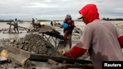 Penduduk desa memisahkan emas dari endapan lumpur, dari limbah tailing operasi penambangan Emas dan Tembaga Freeport AS, di Timika, provinsi Papua, Indonesia, 21 Juli 2008. (REUTERS/Yan Rafsanjani)