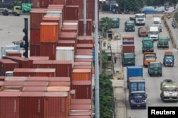 Truk melewati tumpukan kontainer di Pelabuhan Tanjung Priok, Jakarta, 3 Februari 2023. (REUTERS/Ajeng Dinar Ulfiana)