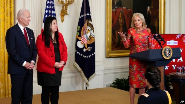 First lady Jill Biden speaks as President Joe Biden and Elaine Tso, CEO of Asian Services in Action, listen during a reception to celebrate the Lunar New Year in the East Room of the White House in Washington, Jan. 26, 2023.