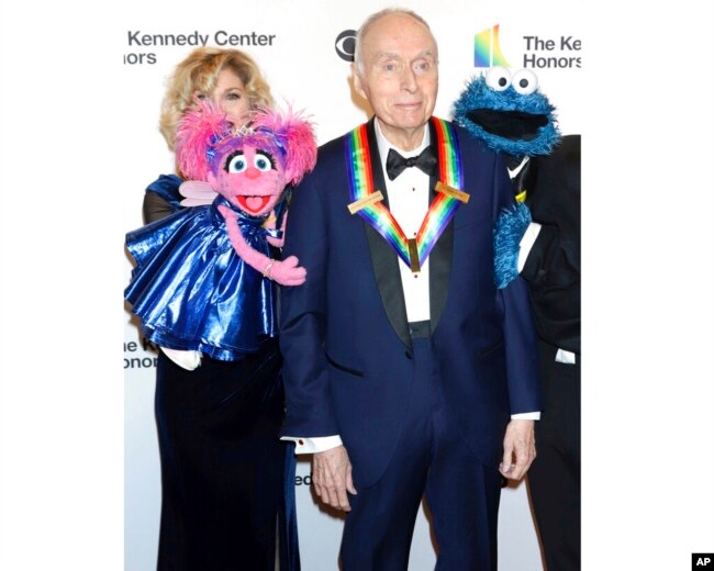 FILE - Honoree Lloyd Morrisett appears with Muppet characters at the 42nd Annual Kennedy Center Honors at The Kennedy Center, Dec. 8, 2019, in Washington.