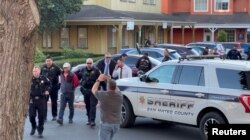 Police officers detain a man, believed by law enforcement to be the Half Moon Bay mass shooting suspect, in Half Moon Bay, California, U.S., January 23, 2023, in this screengrab taken from a social media video. (Kati McHugh via REUTERS)