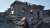 Seorang penduduk setempat duduk di dekat reruntuhan rumahnya yang hancur dalam serangan roket malam Rusia di Zaporizhzhya, Ukraina, 26 Januari 2023.