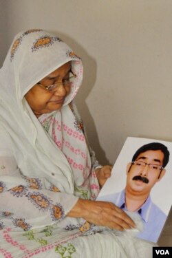 Hazera Bibi holds a photo of her son, Sajedul Islam Sumon. Opposition BNP leader Sumon became a victim of an enforced disappearance after uniformed RAB officers abducted him from Dhaka in 2013. (Abdur Razzak for VOA)
