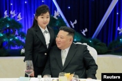 Pemimpin Korea Utara Kim Jong Un berbicara dengan putrinya Kim Ju Ae di sebuah perjamuan untuk merayakan peringatan 75 tahun Tentara Rakyat Korea, di Pyongyang, Korea Utara, 7 Februari 2023. (Foto: KCNA via Reuters)