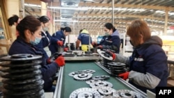 Para pekerja sedang mengerjakan produk aluminium di sebuah pabrik di Huaibei, Provinsi Anhui, China, 30 Januari 2023. (Foto: AFP)