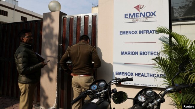 FILE - Police is seen at the gate of an office of Marion Biotech, a health care and pharmaceutical company and a part of the Emenox Group, whose cough syrup has been linked to the deaths of children in Uzbekistan, in Noida, India, Dec. 29, 2022.