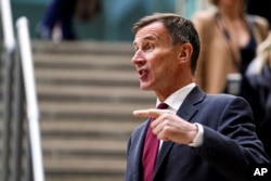 British Chancellor Jeremy Hunt gestures before speaking to the media at Victoria Place Shopping Centre, Woking, in response to the Bank of England Monetary Policy Report, Thursday Feb. 2, 2023. PA Photo. (Jordan Pettitt/PA via AP)