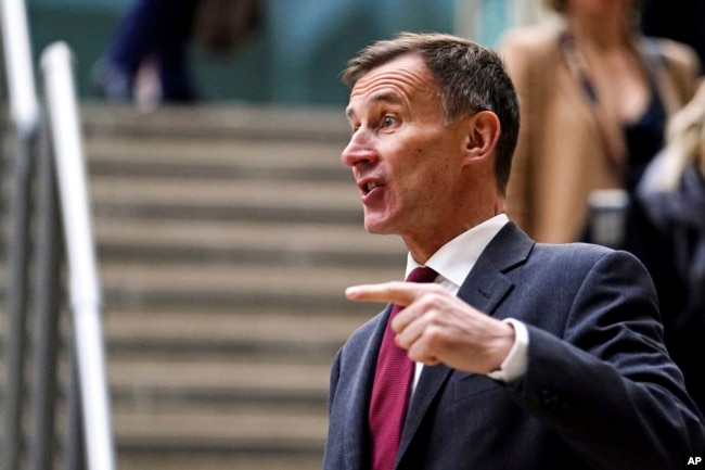 British Chancellor Jeremy Hunt gestures before speaking to the media at Victoria Place Shopping Centre, Woking, in response to the Bank of England Monetary Policy Report, Thursday Feb. 2, 2023. PA Photo. (Jordan Pettitt/PA via AP)