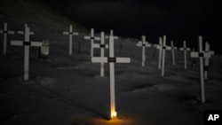 A light glows from the foot of a grave at the cemetery in Longyearbyen, Norway, Jan. 11, 2023.
