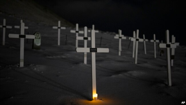 A light glows from the foot of a grave at the cemetery in Longyearbyen, Norway, Jan. 11, 2023.