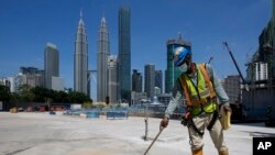 মালয়েশিয়ার কুয়ালালামপুর শহরের কেন্দ্রস্থলে একটি প্রধান রাস্তার পাশে কাজ করছেন একজন নির্মাণ শ্রমিক। ১৫ অক্টোবর, ২০২১। (ফাইল ছবি) 