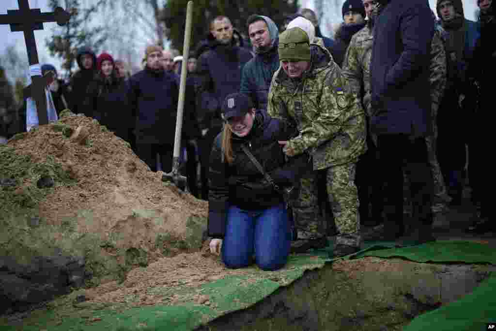 Anya Korostenska drops to her knees at the grave of her fiance Oleksiy Zavadskyi, a Ukrainian serviceman who died in combat on January 15 in Bakhmut, during his funeral in Bucha, Ukraine.